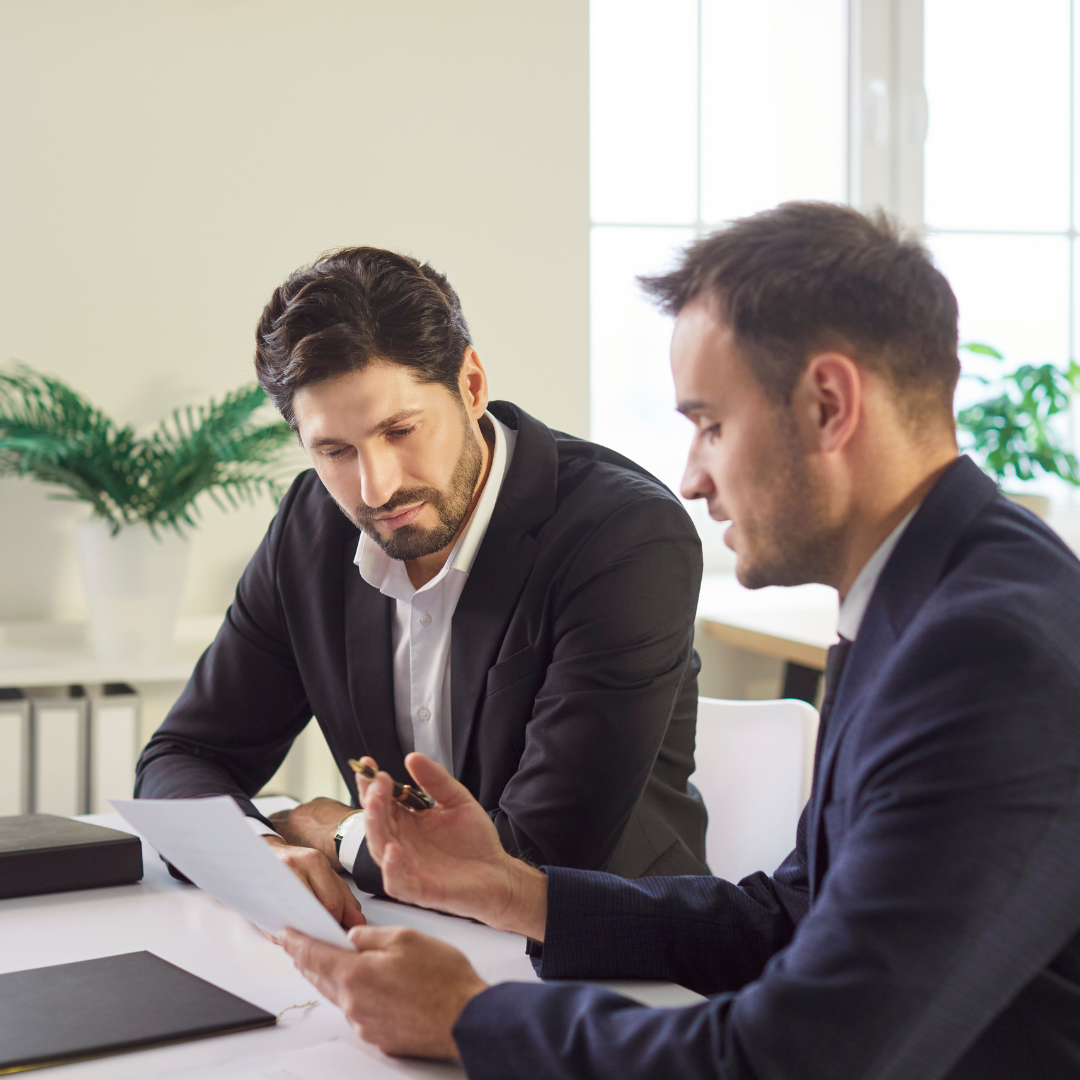 Two professional solicitors discussing legal documents in a modern office setting – Martin Shepherd Solicitors, legal advice in Hertfordshire and North London.