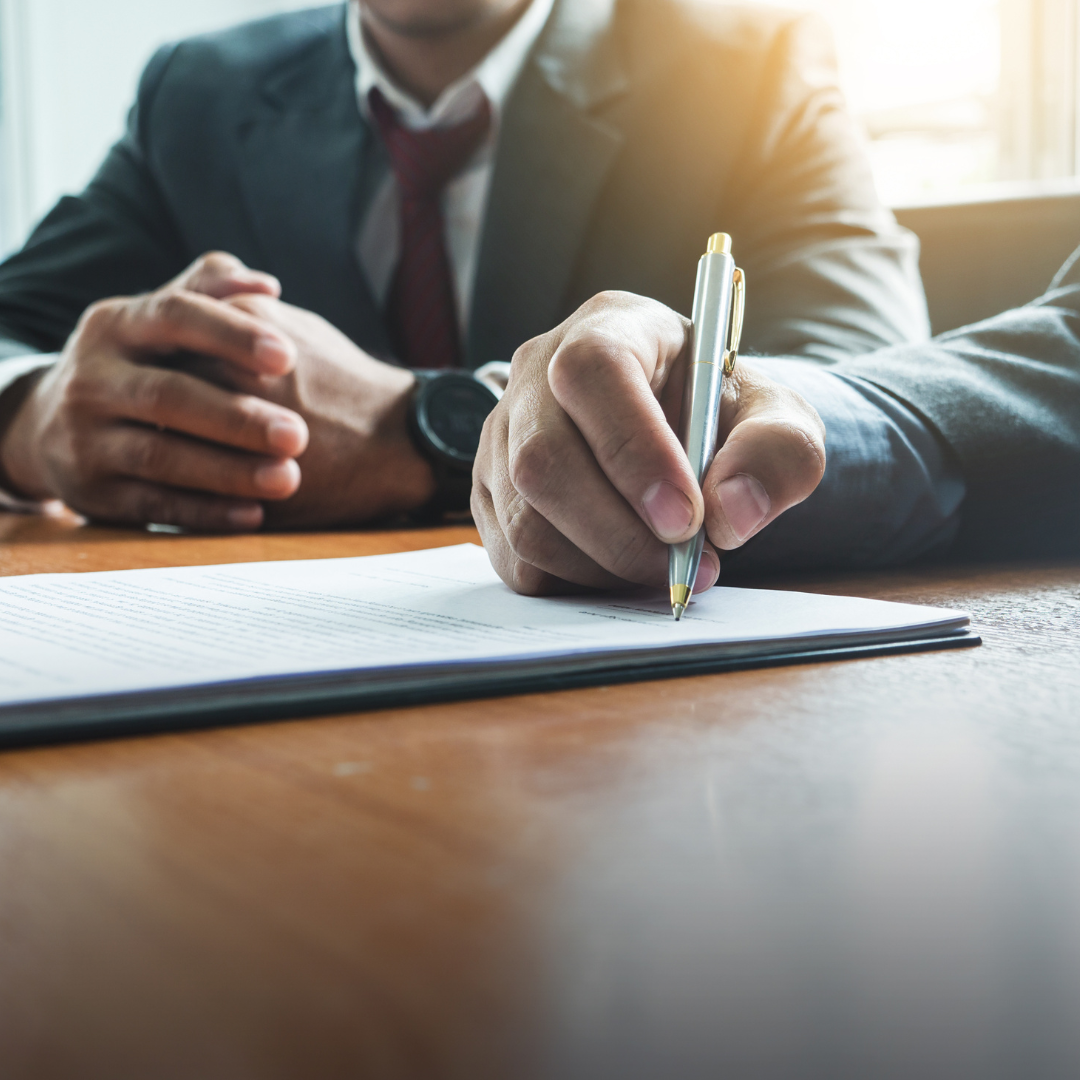 Close-up of a person signing an agreement at a desk representing how Martin Shepherd Solicitors help with director and senior employee service contracts in Potters Bar, Hertford, and Finchley.