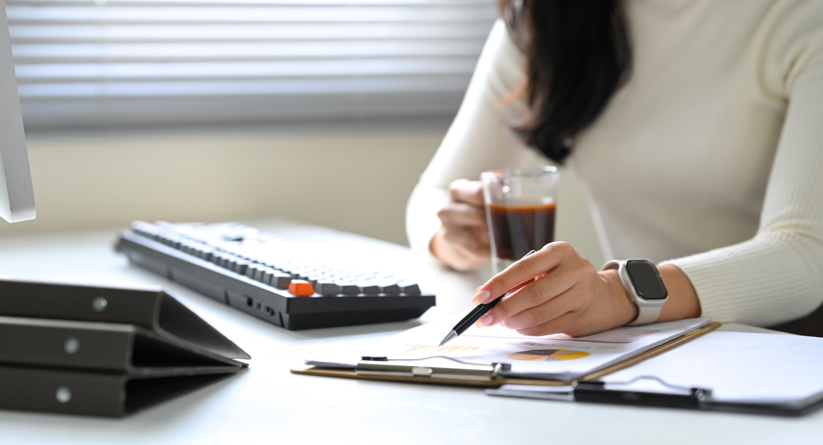 Person reviewing legal documents with coffee in hand representing wills and estate planning advice by Martin Shepherd Solicitors in Potters Bar, Hertford, North Finchley, North London and Hertfordshire.